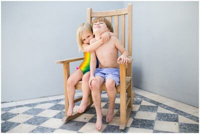 A sweet hug between siblings caught at the Walter Family Bedtime Story by lifestyle photographer Audrey Blake Breheney