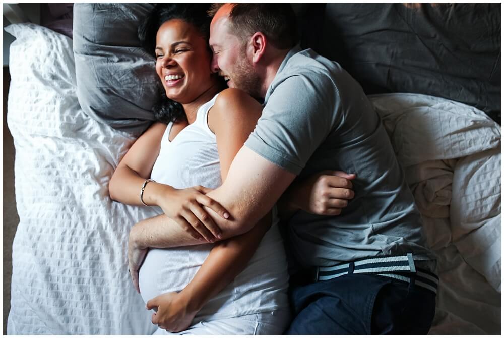 A couple days away from the arrival of their first child, laughing and snuggling in bed. Maternity Lifestyle at home session, audrey Blake, Audrey blake photography