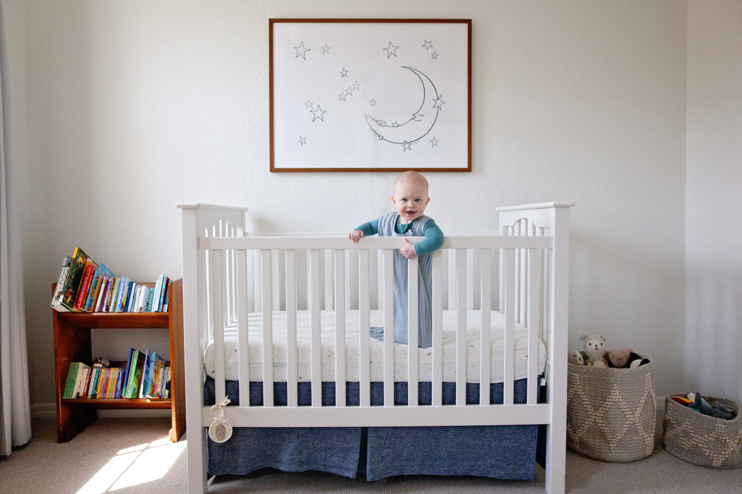 Laughing baby boy standing up in crib