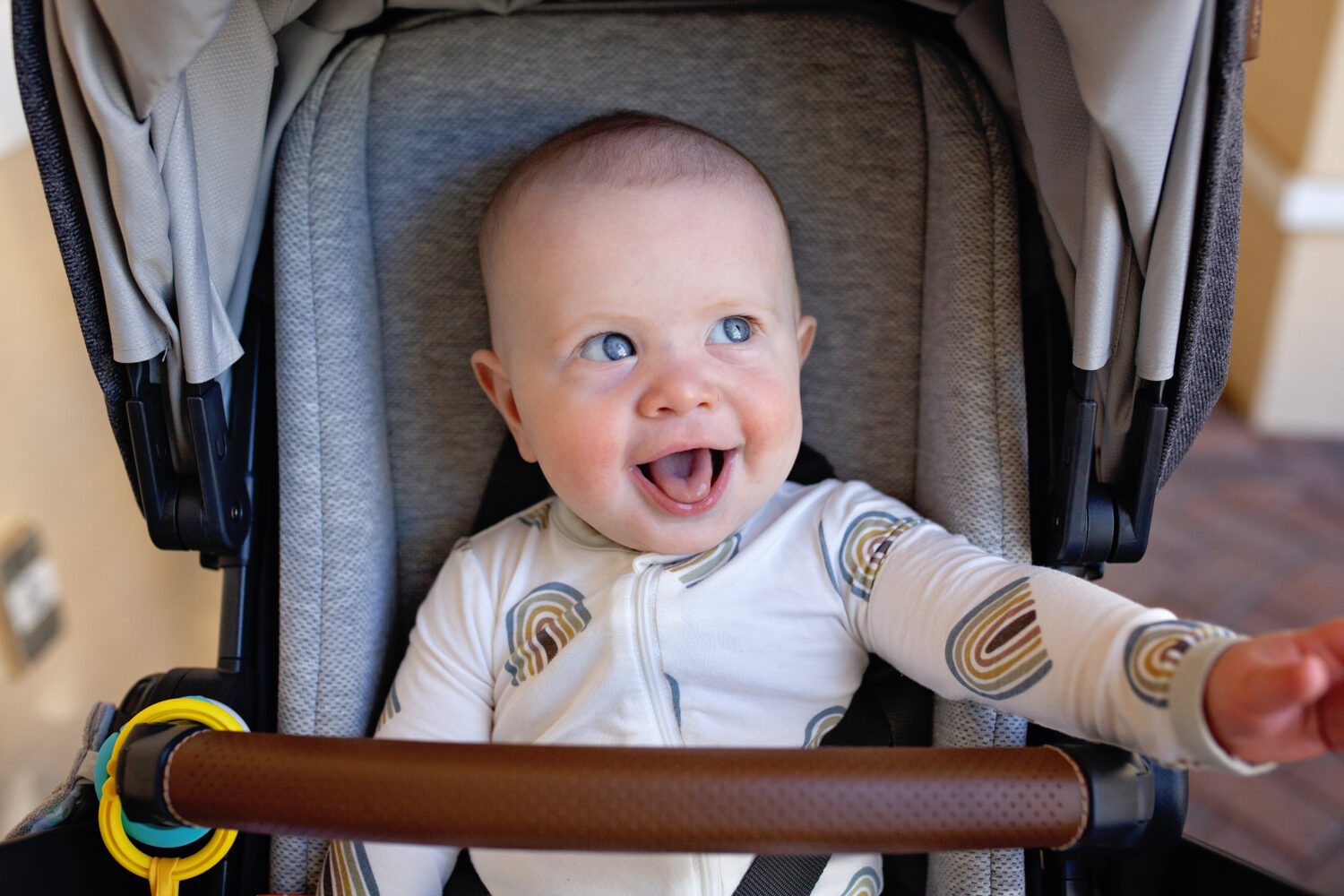 laughing baby in stroller ready for a nap