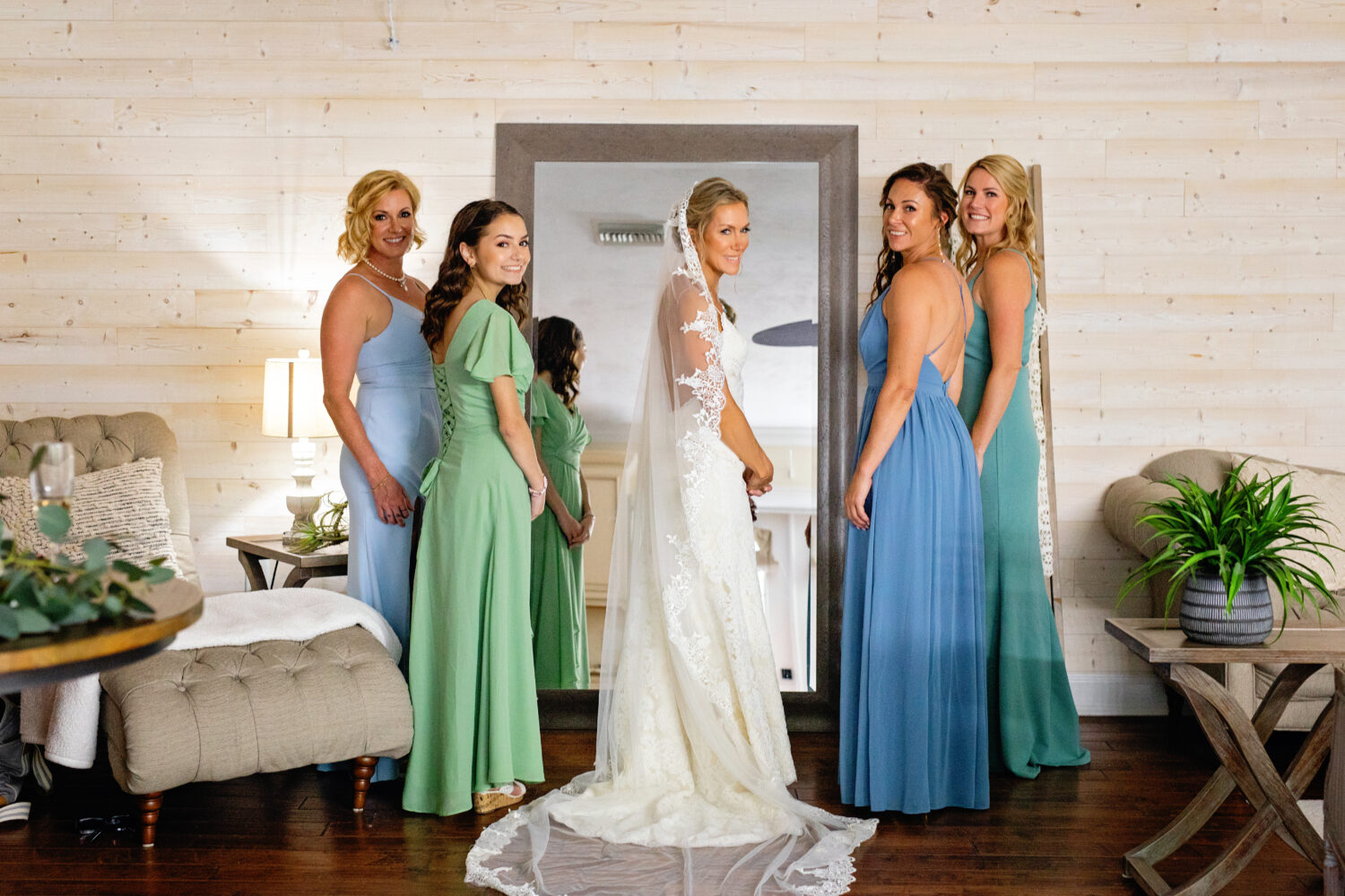 bride with all her bridesmaids at the mirror