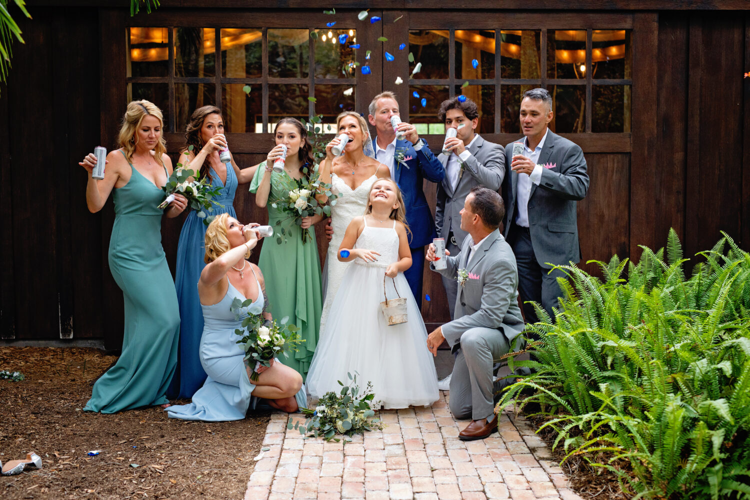 bridal party and groomsman chugging white claw and flower girl throwing flowers in the air