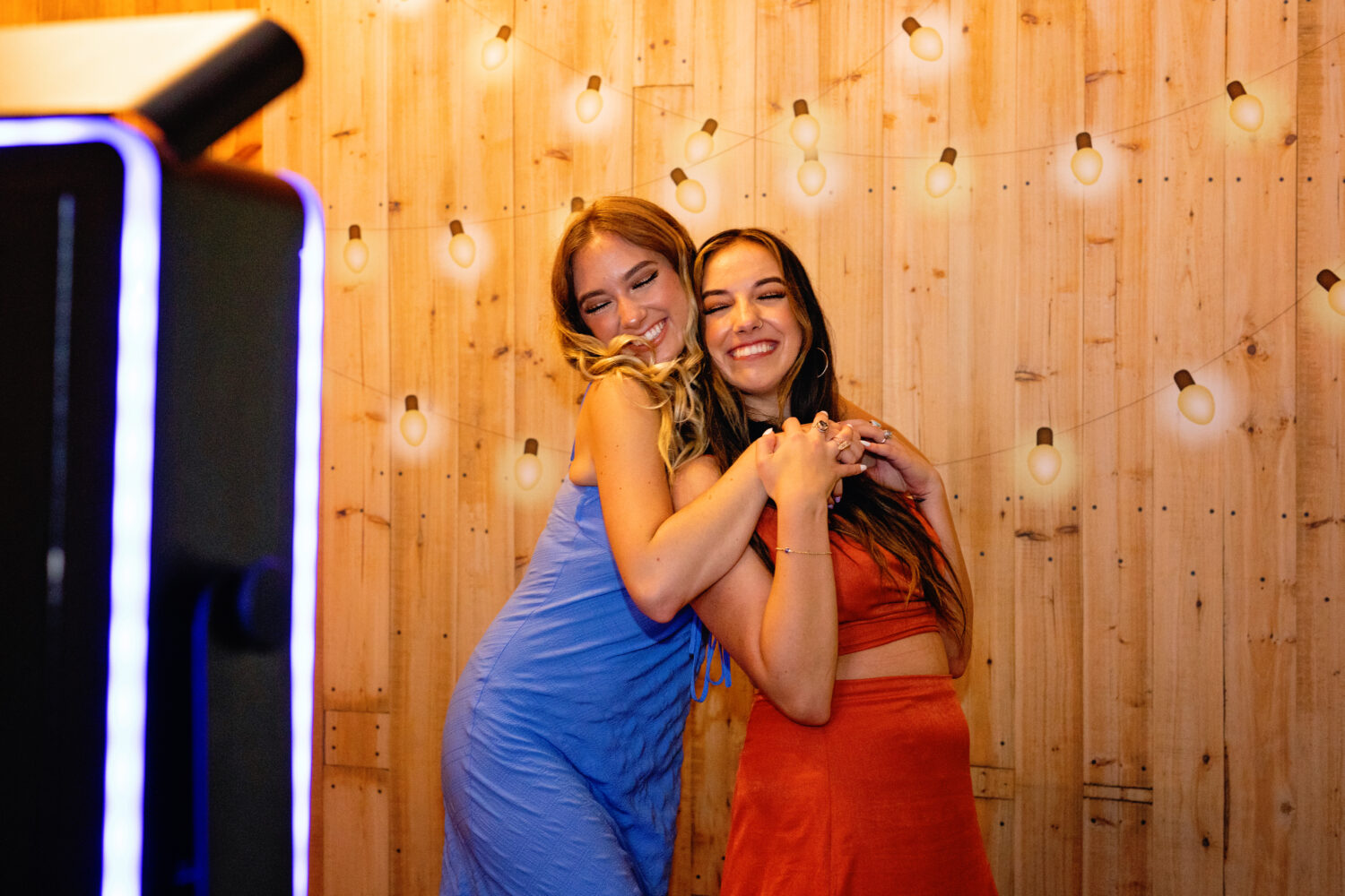 two pretty girls taking photos at a photo booth